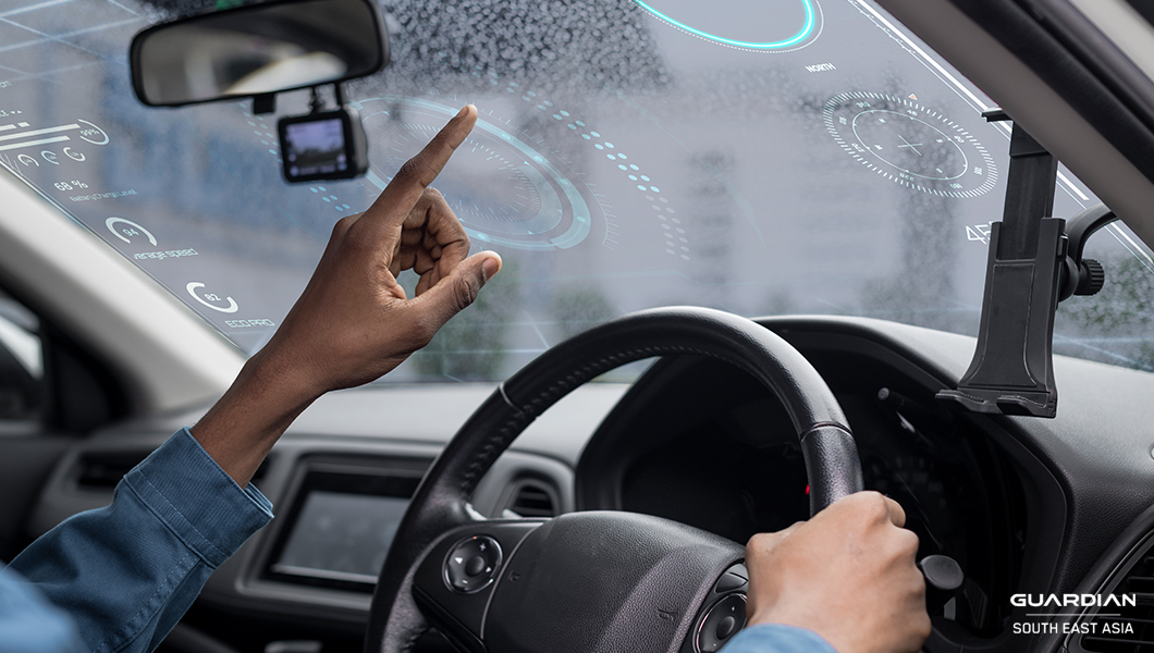 man in car pointing at window