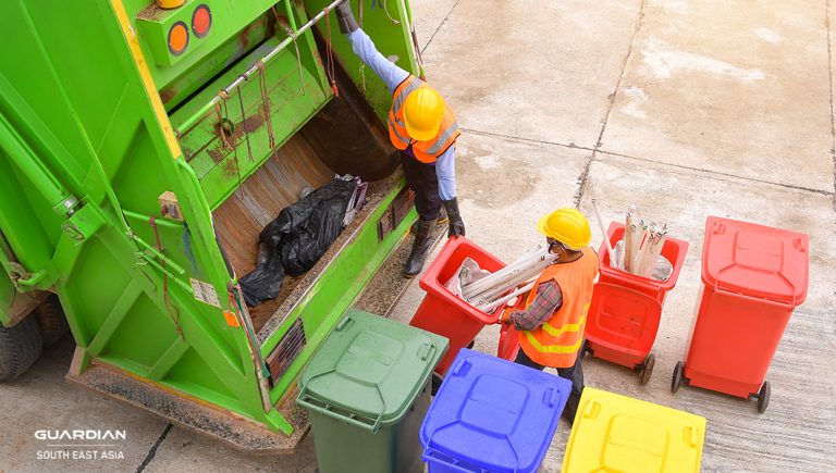 workers unloading trash bins