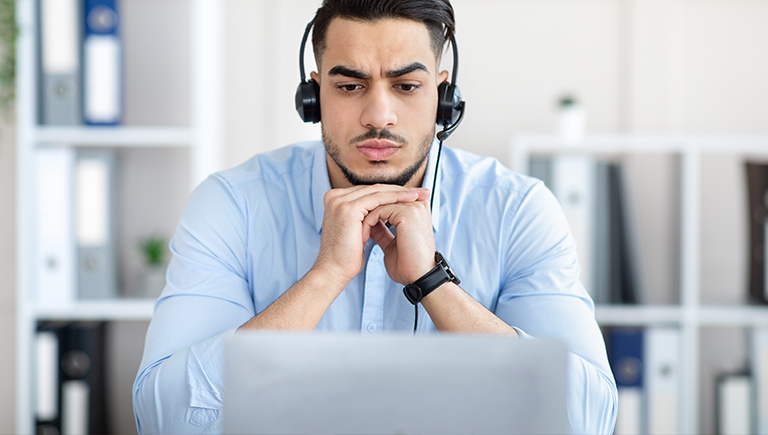 man with headphones looking at laptop