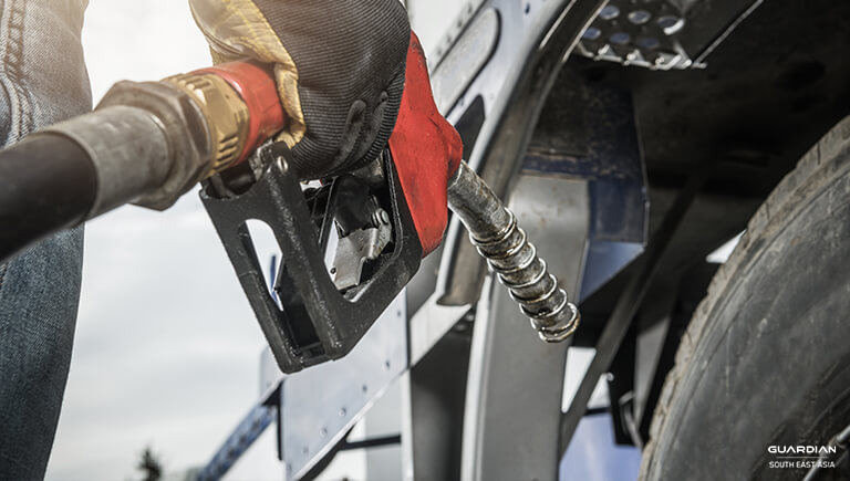 man with gloves holding gasoline pump