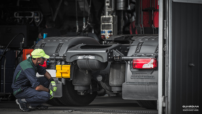 man checking car while crouching