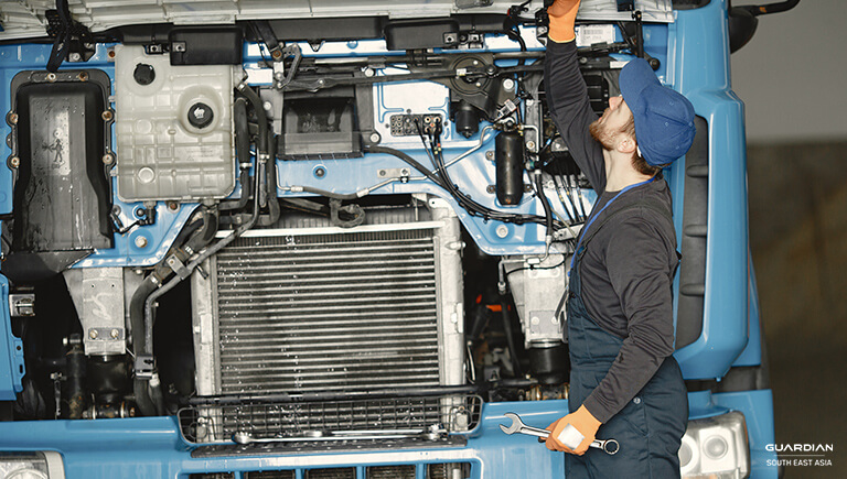 man fixing truck engine