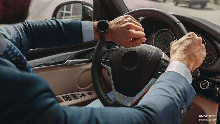 man in suit holding the steering wheel